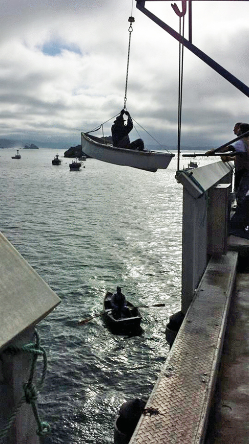 Local crabber, Jim Habib, is raised out of the water today after visiting his boat in Trinidad. (Photo by Mike Perry.)
